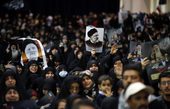 21일(현지시간) 테헤란의 모샬라 모스크에서 열린 추모식에서 이란 국민들이 고 에브라힘 라이시 대통령과 호세인 아미르-압돌라히안 외무장관 사진을 들고 애도하고 있습니다. EPA 연합뉴스